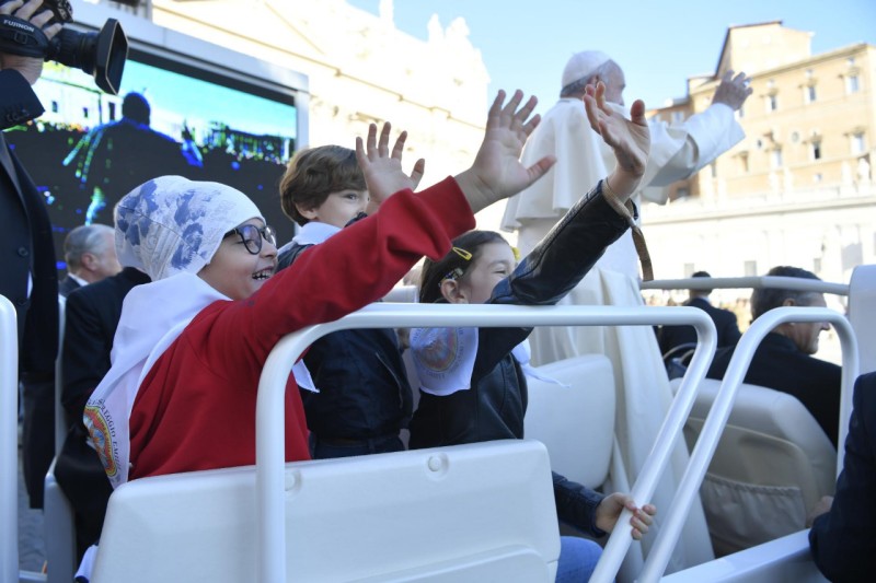 Los niños y el Papa saludan desde el jeep