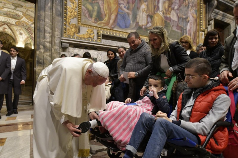 El Papa coloca un calcetín a un niño